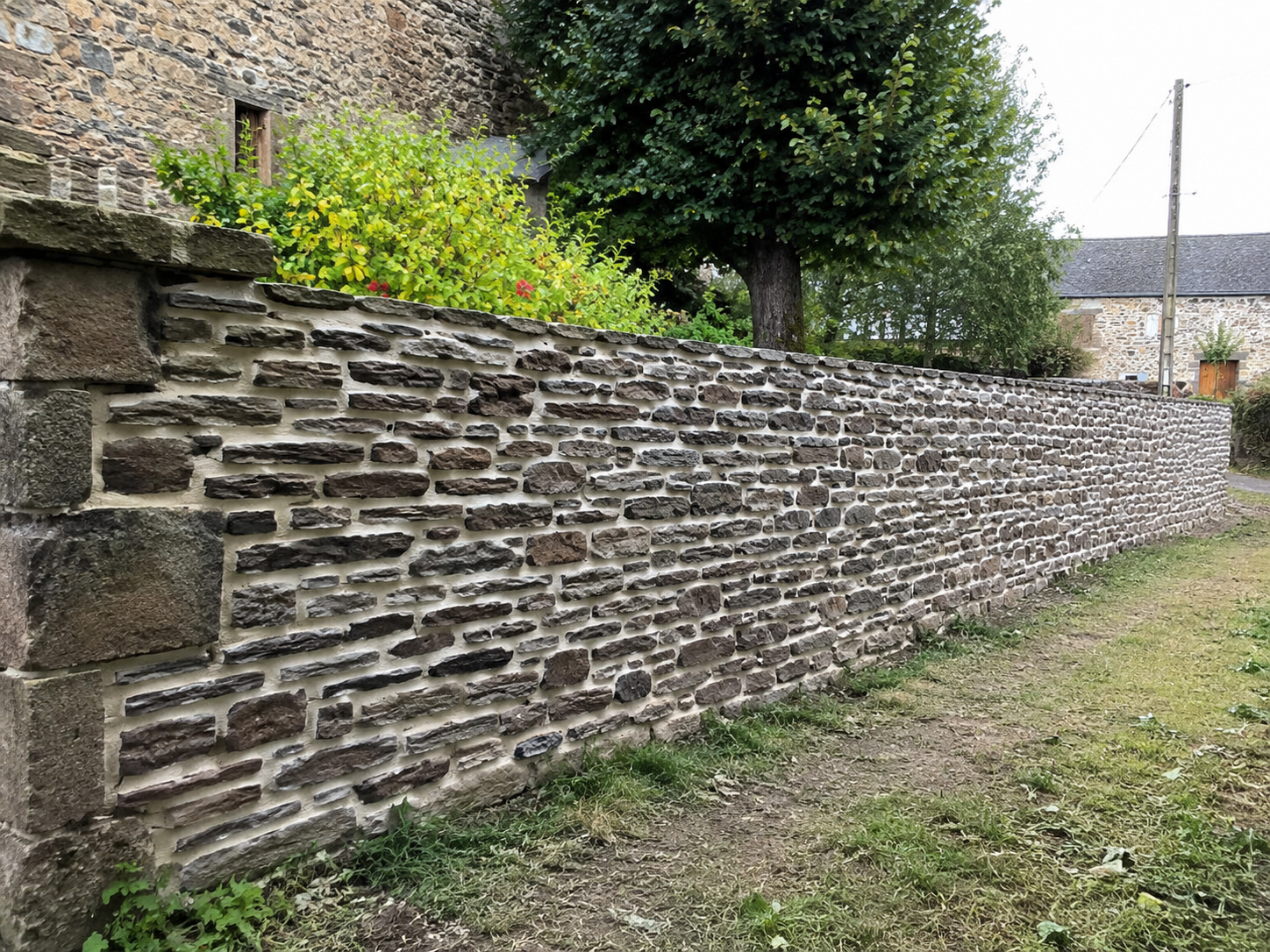 Mur en pierre reconstruit et rejointoyé proprement à Vallons-de-l'Erdre
